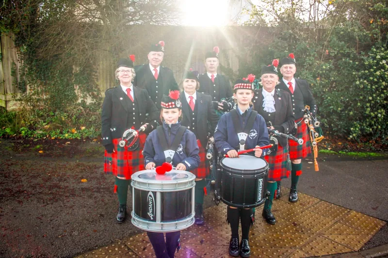 Young drummers at the front of the band with sunlight behind