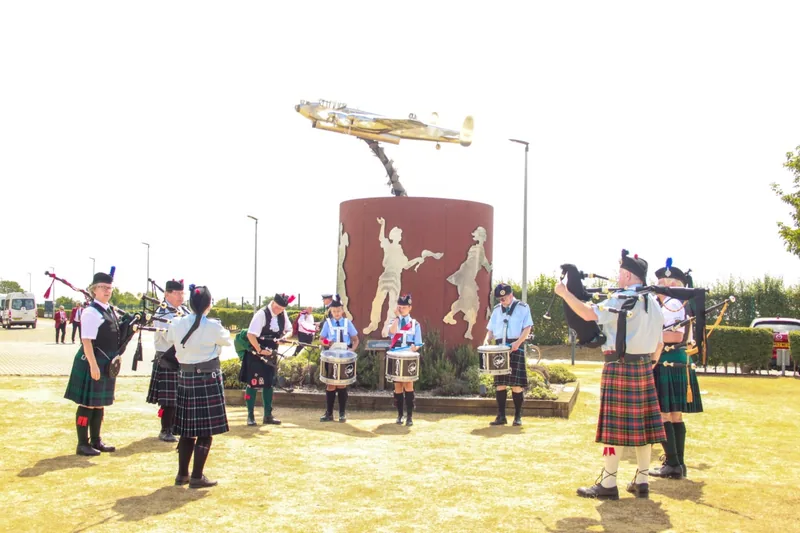 Pipers and drummers playing at the Lancaster memorial on International Bomber Command Day