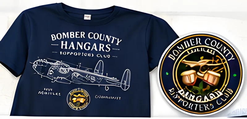 A navy Bomber County Hangars Supporters Club T-shirt with a Lancaster print, and the round crest window sticker