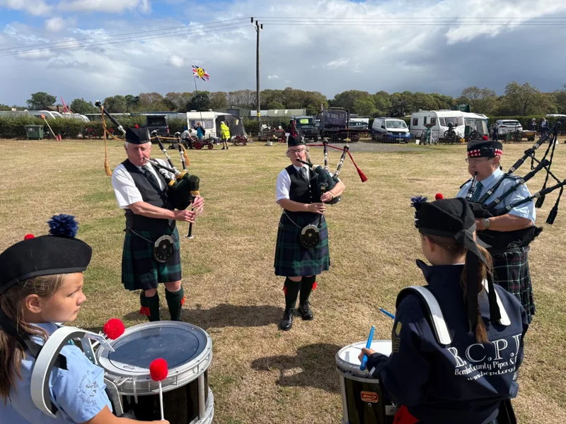 Young drummers and pipers playing together on a showground